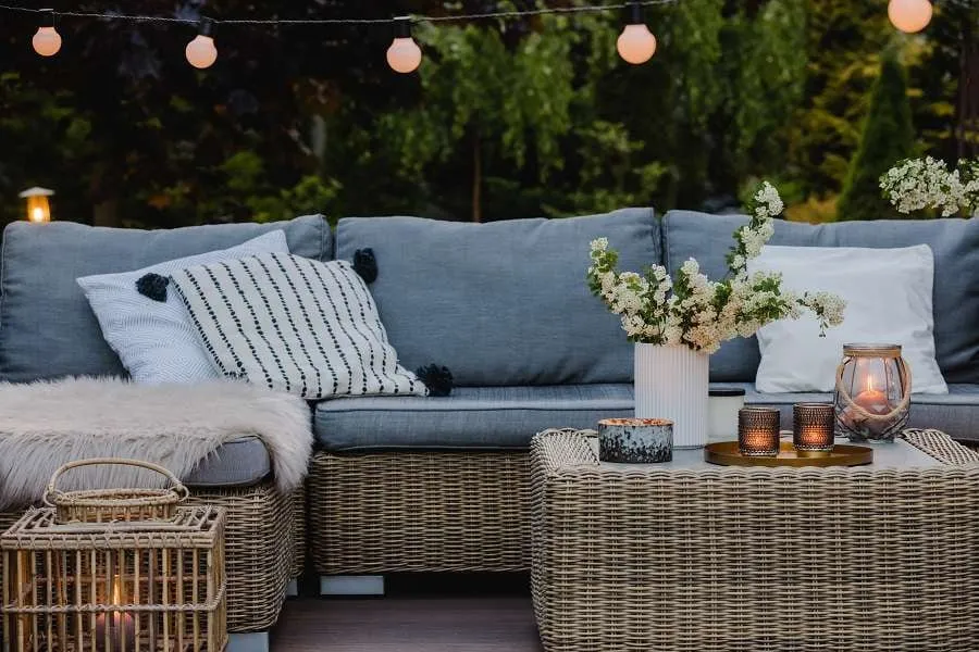 Eine Terrasse mit Rattanmöbeln und Kerzen als Schutz gegen Insekten.
