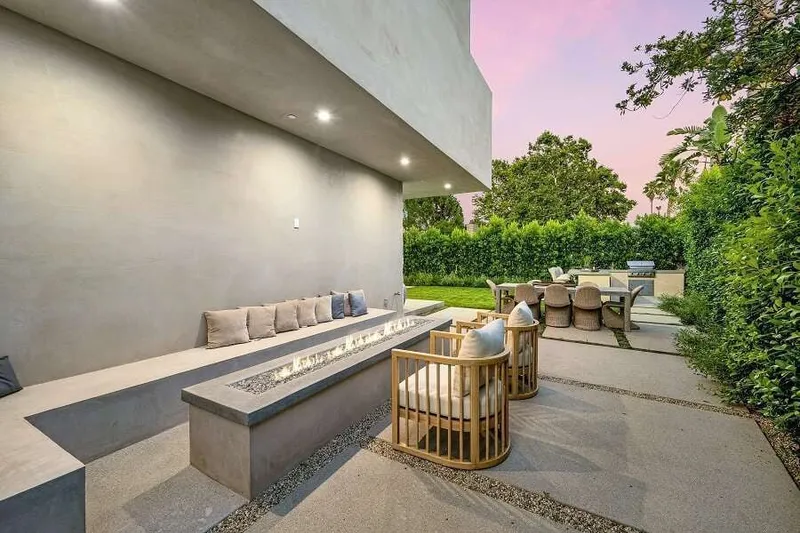 Eine moderne Terrasse mit Steinmaterialien und Möbeln aus Holz