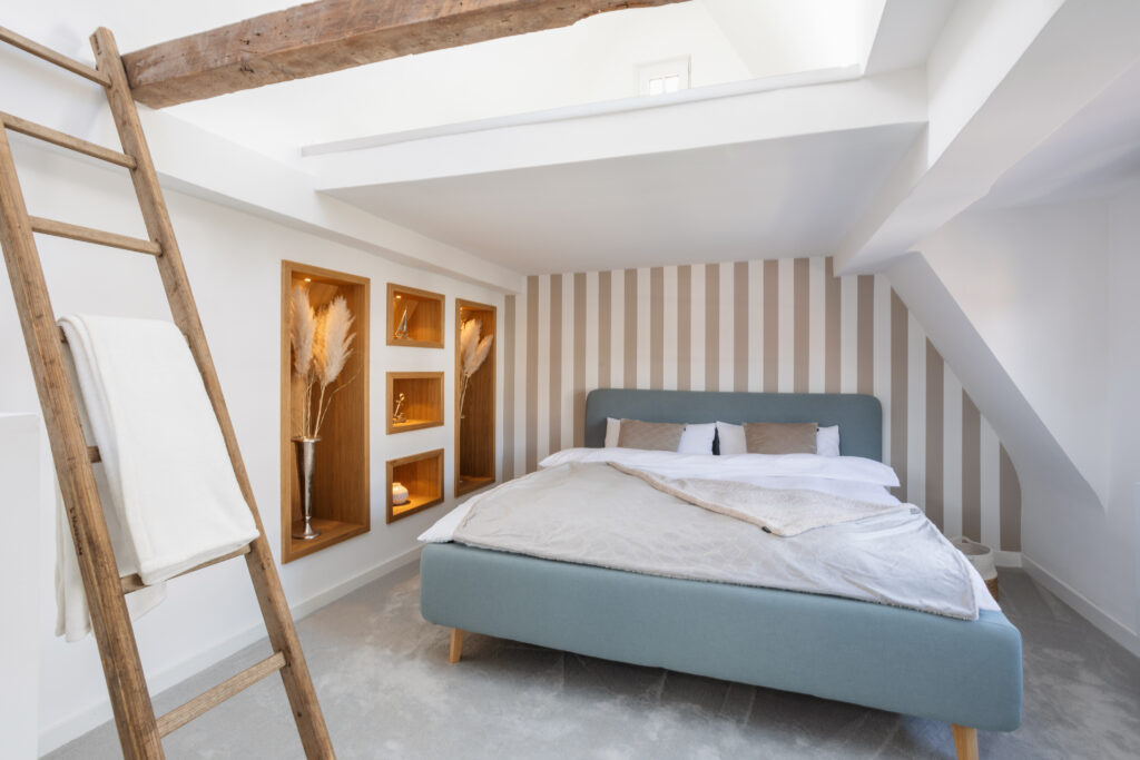 Ein gemütliches Schlafzimmer mit einer zweifarbigen Tapete an der Wand