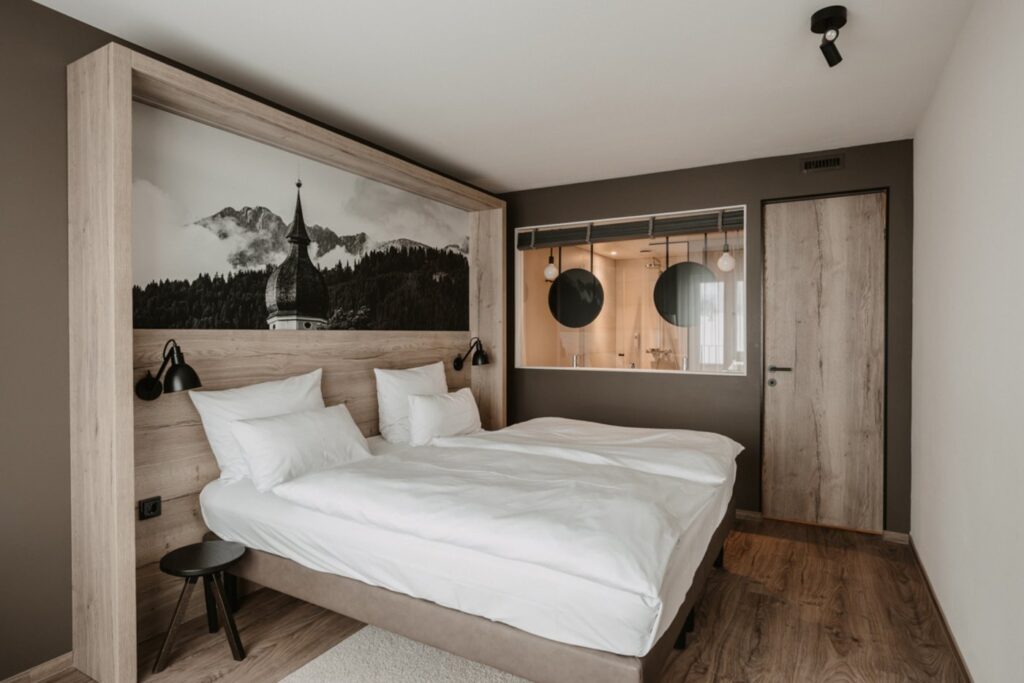 Ein Hotelzimmer mit gemütlichem Bett, das mit natürlichen Materialien eingerichtet wurde