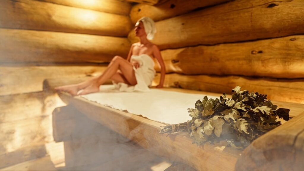 Eine Frau entspannt in ihrer eigenen Sauna zuhause. 