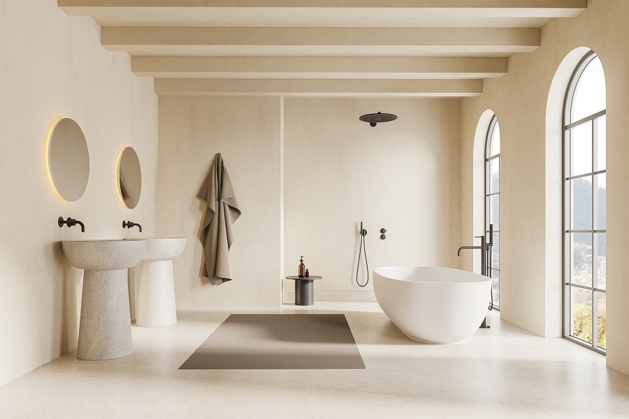 Ein stilsches, fugenloses Bad, das in hellen Tönen und mit einer freistehenden Badewanne gestaltet wurde