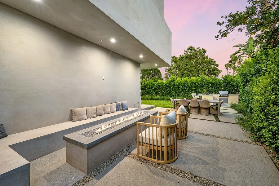 Eine moderne Terrasse mit Steinmaterialien und Möbeln aus Holz