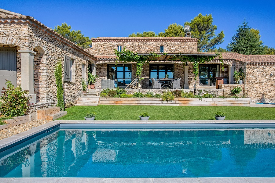 Ein mediterranes Haus mit Garten und Pool im Sommer